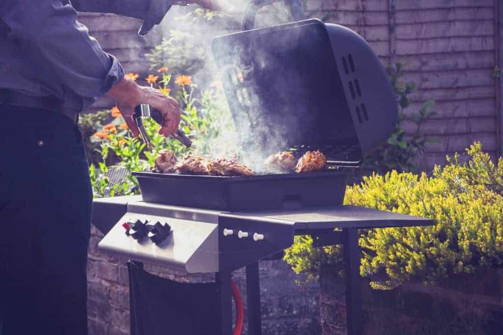Man Barbecuing On Gas Grill